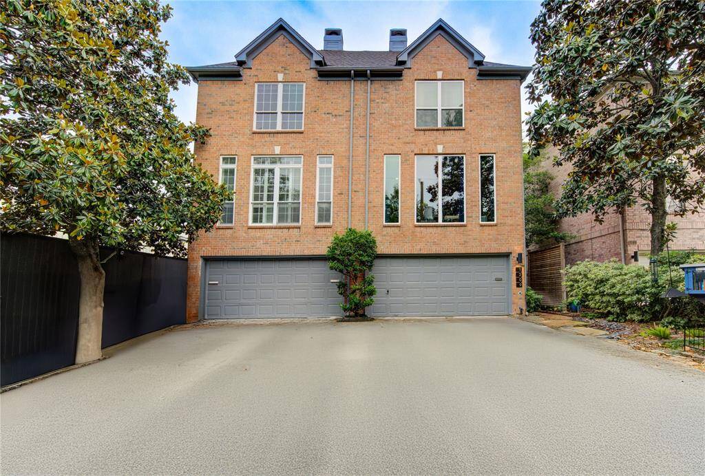 Welcome to 1209 Van Buren—this stunning townhome with 2-car garage offers charming curb appeal with its timeless brick façade and elegant architectural detailing