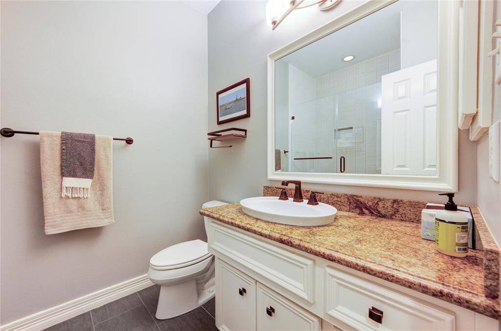 The granite-topped vanity includes upgraded fixtures and ample storage, blending elegance with everyday convenience. Ideal for guests or a private suite setup on the lower level.