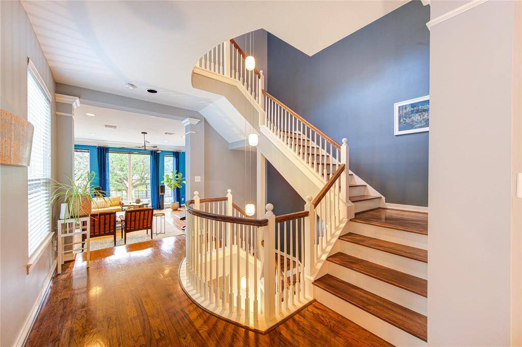 The open design enhances the flow between levels, while the warm tones of the hardwood add a sophisticated touch that ties into the home’s overall modern aesthetic.