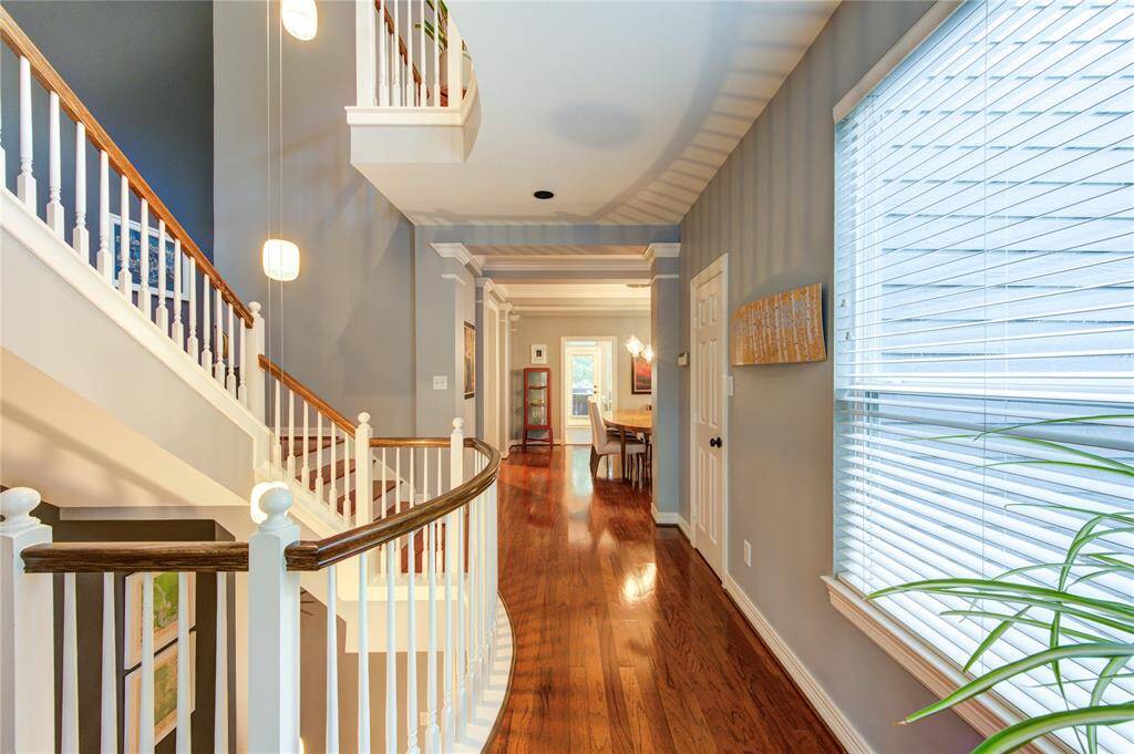 The elegant stairway is a striking architectural feature, showcasing rich wood treads, crisp white risers, and wood handrail accents.
