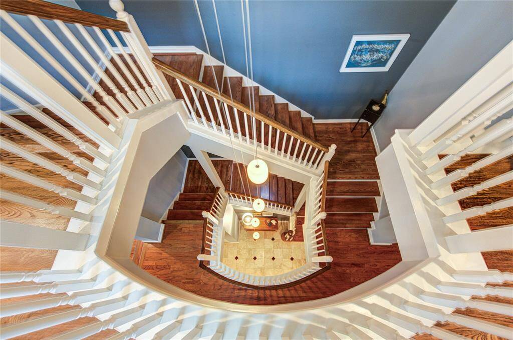 From the third level, enjoy a stunning view of the grand staircase with wood treads as it cascades down to the lower floors.