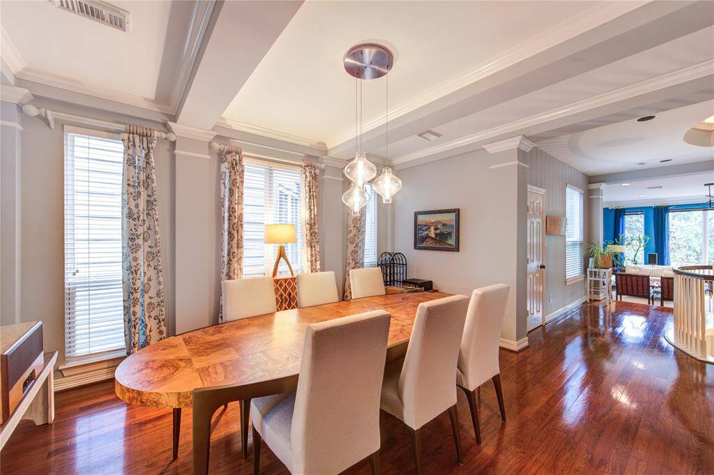 The formal dining area flows seamlessly from the living room, offering ample space for hosting dinner parties. A designer chandelier and custom millwork add sophistication, while easy access to the kitchen makes serving effortless.