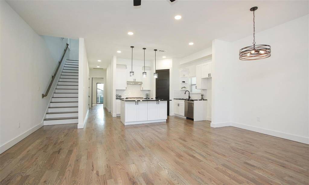 View toward the modern front door from the kitchen showcasing the abundant natural light.