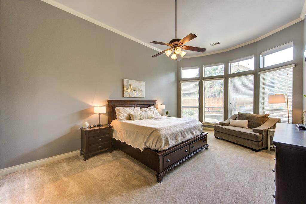 Large primary bedroom with remote controlled upper shades with an upgraded bay window. 21 feet by 14 feet