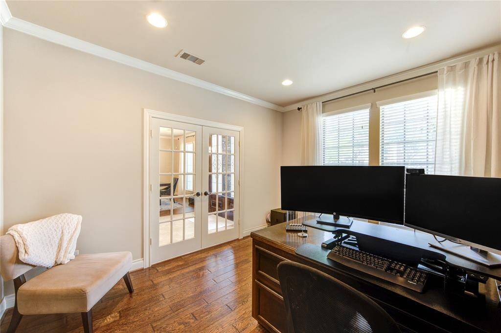 Private office space with a custom built-in wood desk with crown molding and natural light on beautiful wood floors. 13 feet by 11 feet