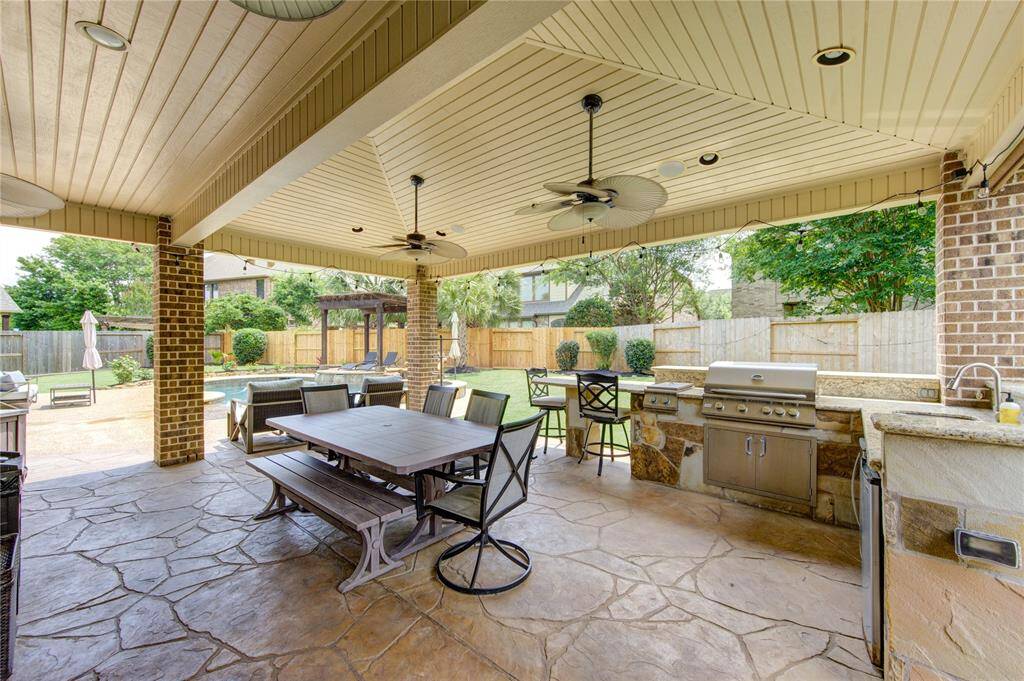 Create family memories under the enjoyable massive outdoor covered patio with a summer kitchen next to the pool and green spaces