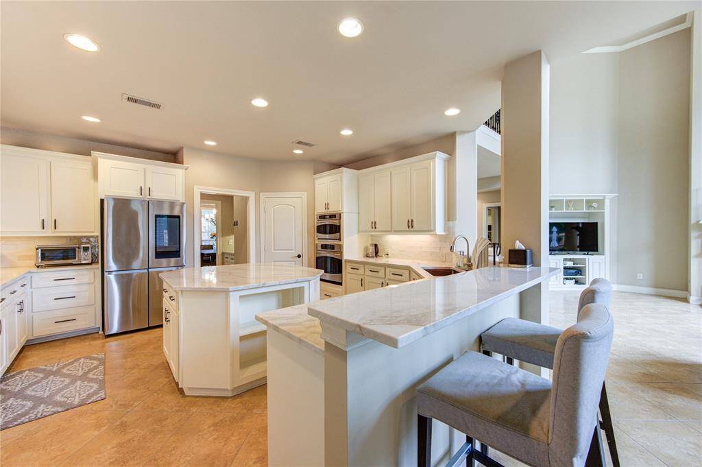 Well appointed and updated kitchen space with 55 soft close cabinets and drawers with a separate coffee bar and walk-in pantry, counter seating opening to the living area and connected to the dining room