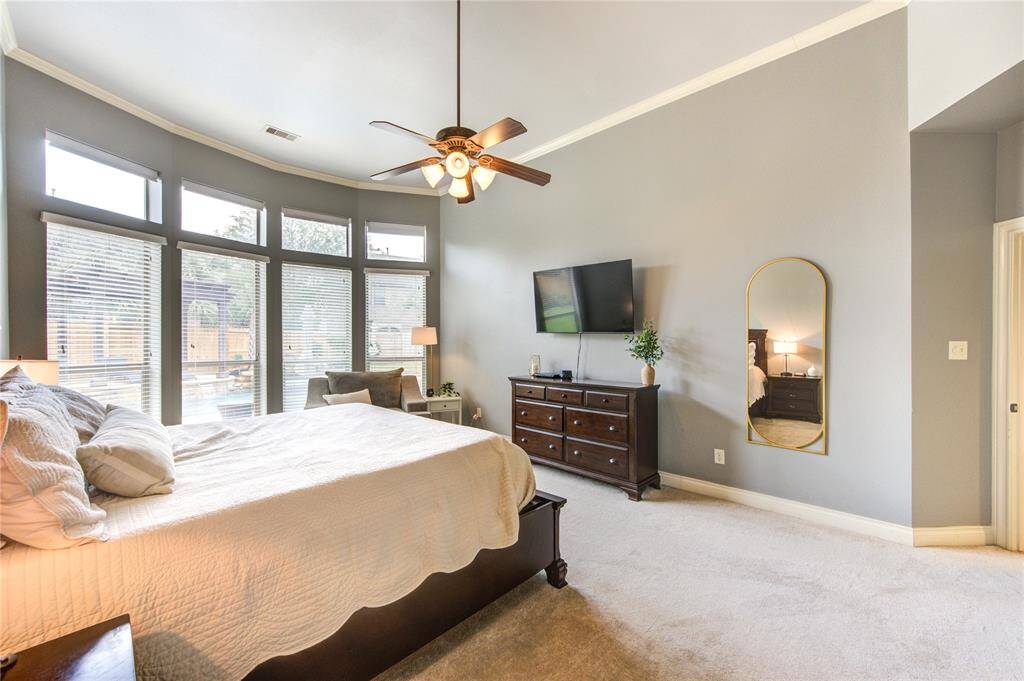Large primary bedroom with remote controlled upper shades with an upgraded bay window. 21 feet by 14 feet