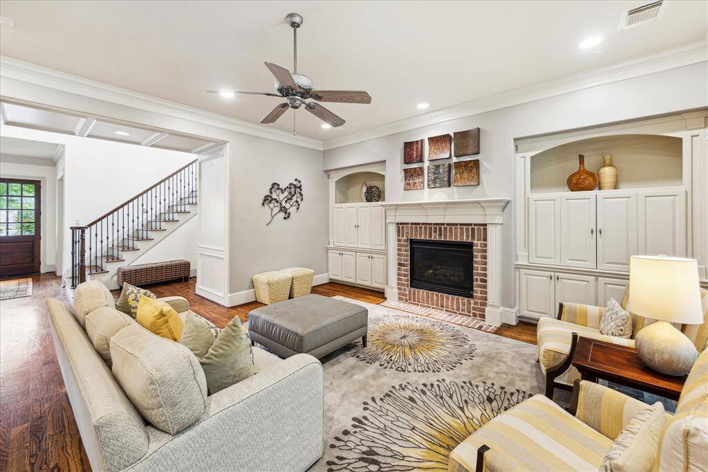 The living room features a cozy brick-surround fireplace, complemented by custom built-in shelves.