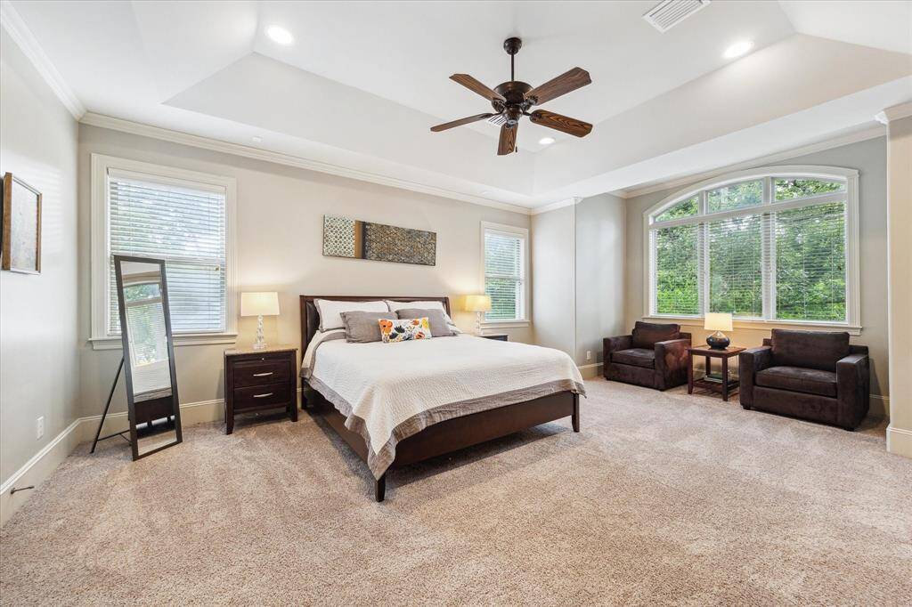 The luxurious primary suite includes a cozy sitting area, providing a spacious retreat for relaxation.