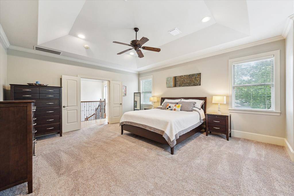 The primary bedroom, accessed through double doors, features high ceilings and offers ample space to accommodate large furniture pieces with ease.