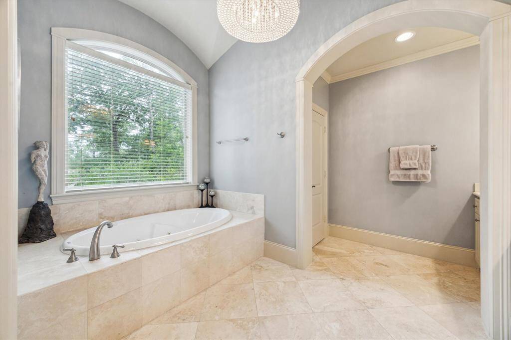 Relax and unwind in the luxurious jetted tub, surrounded by elegant travertine.