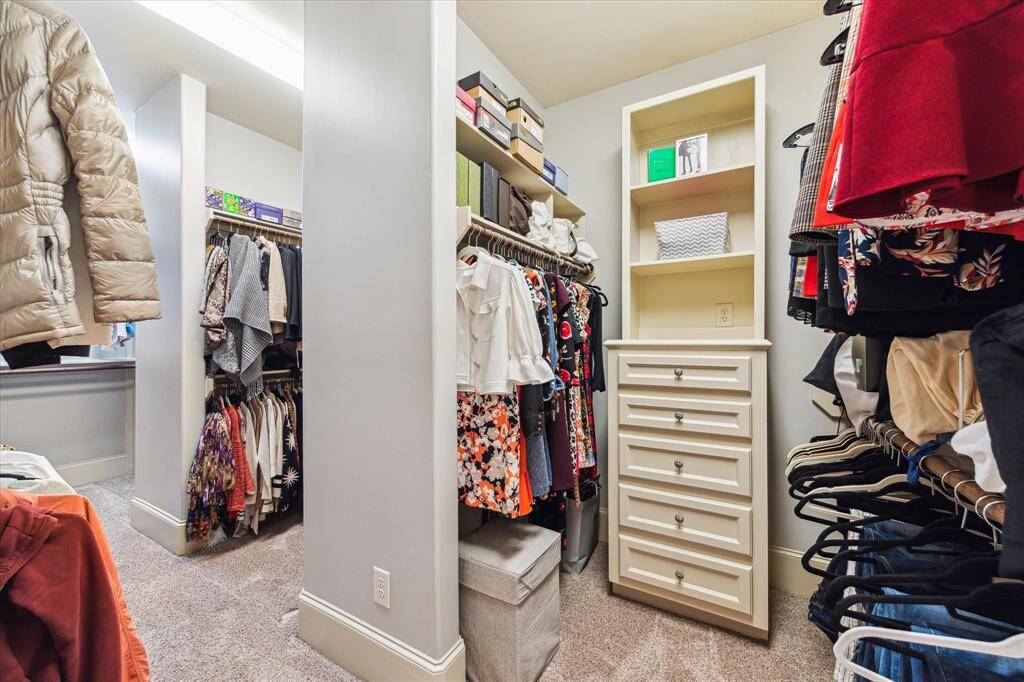 The expansive walk-in closet features three distinct sections and custom built-ins, providing exceptional storage and organization.