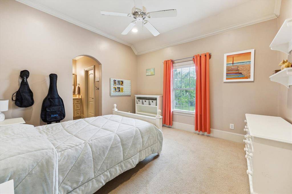 The secondary bedroom, overlooking the front yard, features a ceiling fan,spacious walk-in closet and vanity sink.