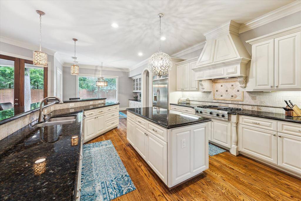 The gourmet kitchen is equipped with dual sinks, a center island with a built-in microwave, and a professional-grade Viking gas range.