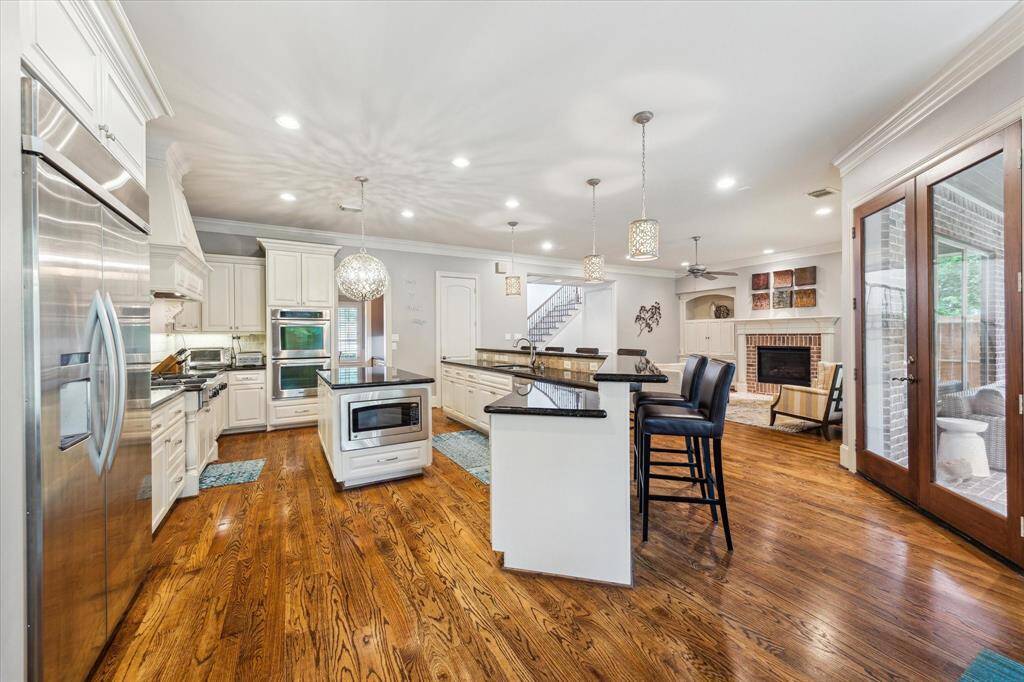 The kitchen also boasts a built-in refrigerator with an ice and water dispenser, dual convection ovens, and a spacious breakfast bar with plenty of seating.