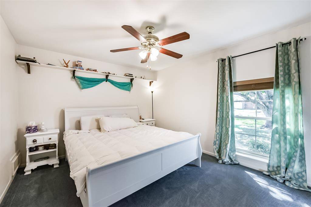 Bedroom with large window to let in natural light and ceiling fan with light