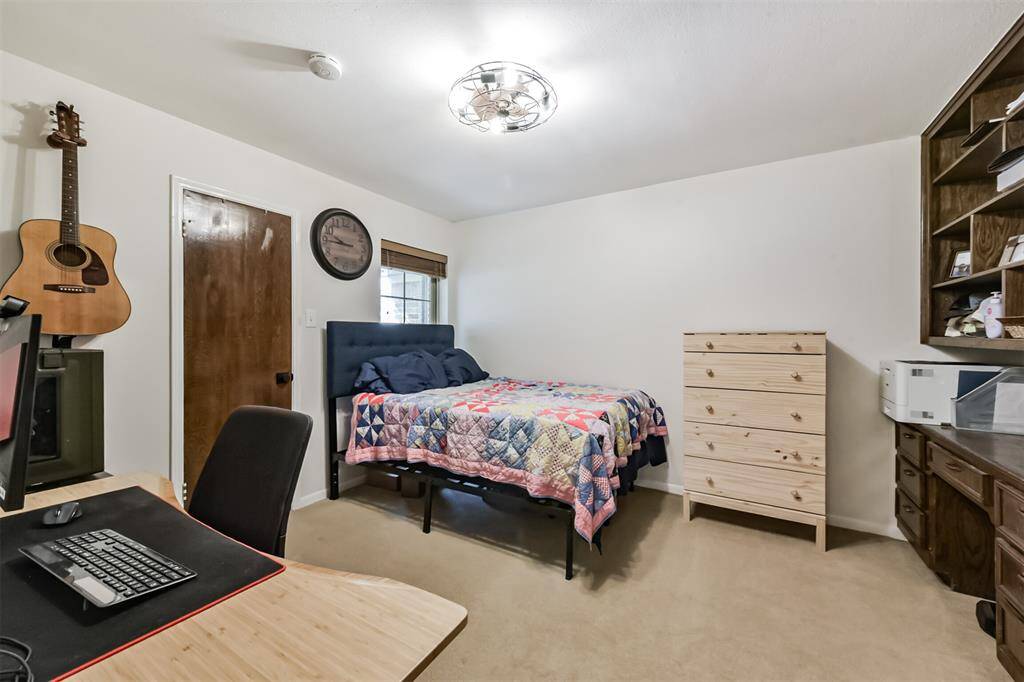 Secondary Bedroom with updated light fixture, double pane window, and walk-in closet