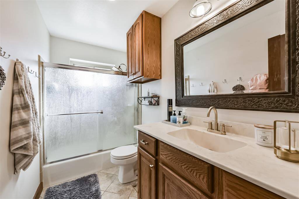 Updated counter top in secondary bathroom with shower/tub combo, tile floors and plenty of storage cabinets
