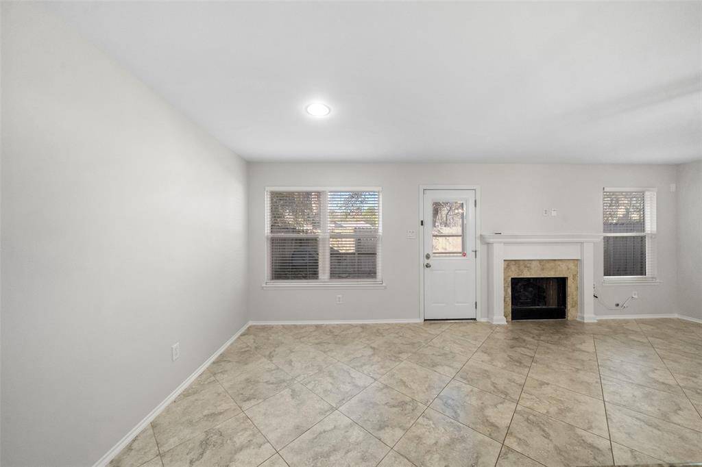 View of the back door, complemented by a wall of windows that fill the space with natural light creating a warm and inviting atmosphere.