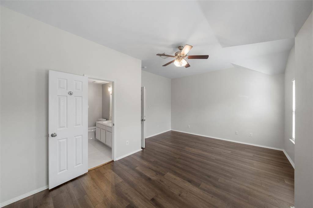 Another great view of the spacious primary bedroom, bathed in natural light and enhanced by stylish lighting, creating a bright and inviting atmosphere.