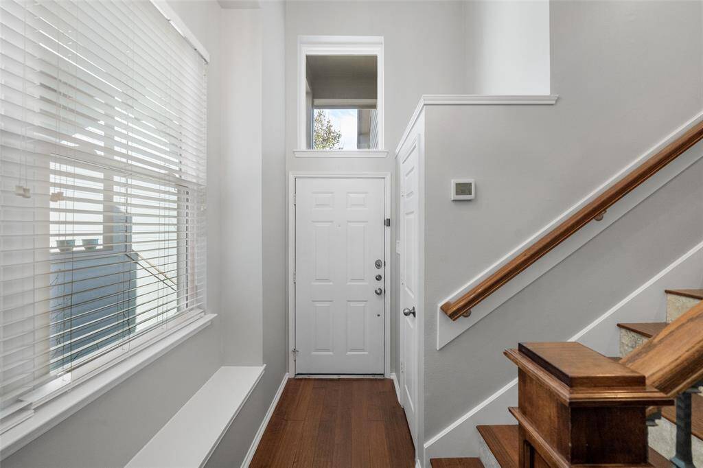 Step into the inviting foyer, showcasing soaring high ceilings, a stylish new light fixture, and freshly painted walls for a modern, welcoming ambiance.