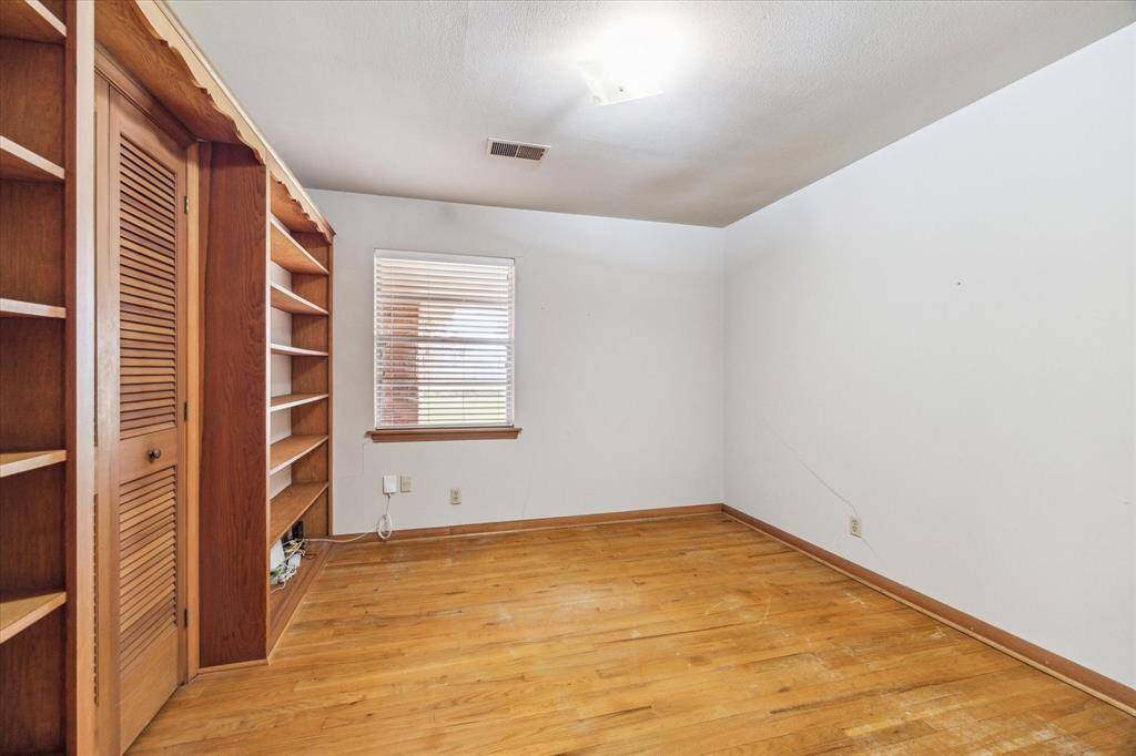 Bedroom 4 has been used as a study/office with built-in shelves and large closet. Window faces the backyard with covered patio.