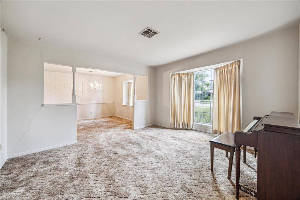 Formal living room with large picture window to bring in the morning sun. Adjacent formal dining room is ideal to open walls and create an office.