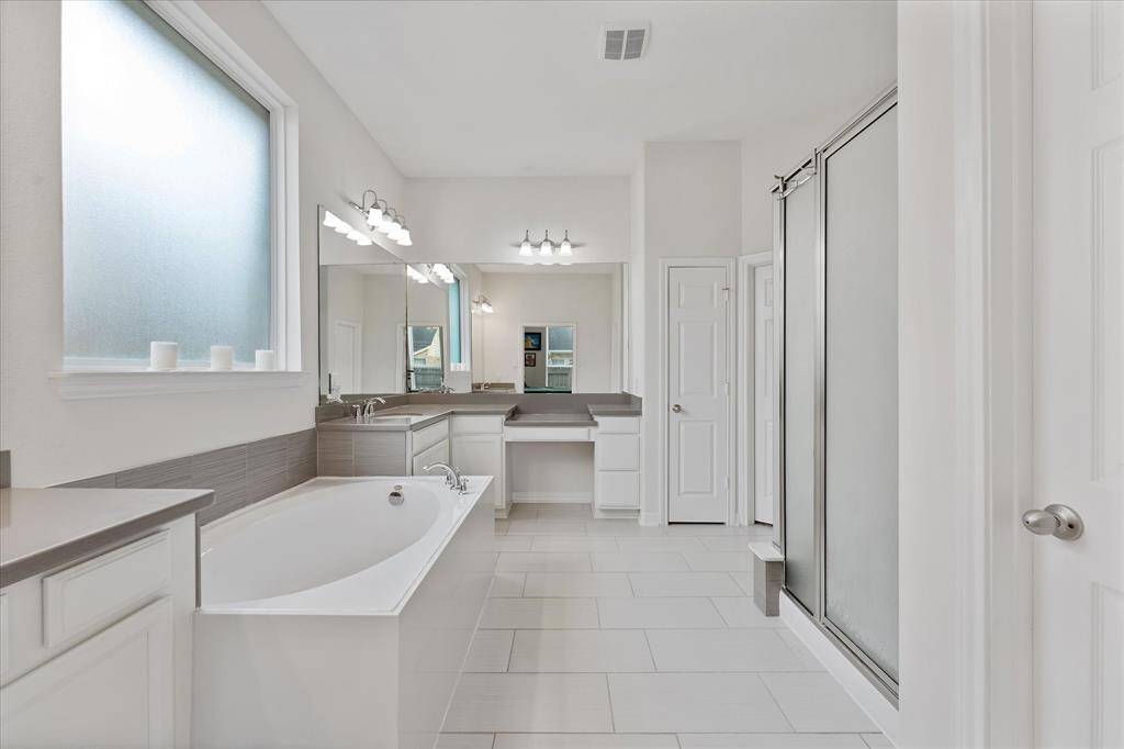 Luxurious primary bath with dual vanities, make-up vanity, deep soaking tub ad spacious separate shower