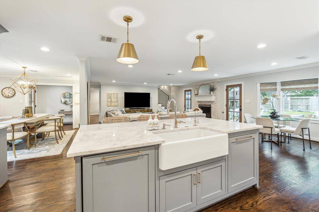 Spacious open floor plan overlooks the living and dining rooms. Porcelain farmhouse sink, marble island and designer pendants.