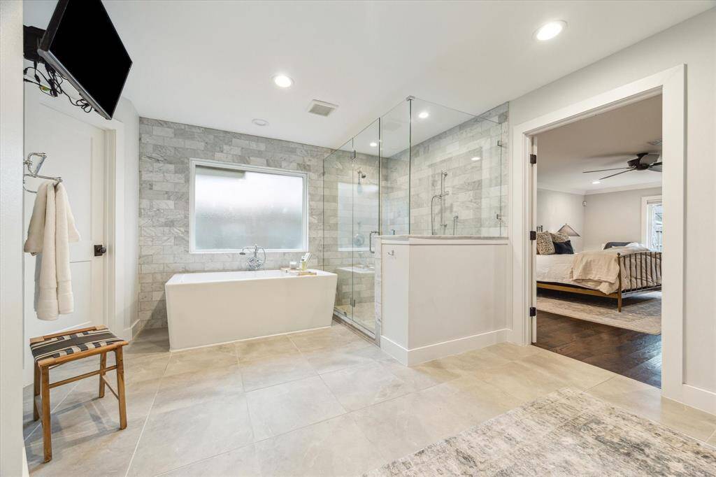 Luxurious soaking tub and large walk-in shower with two shower heads and built in bench.
