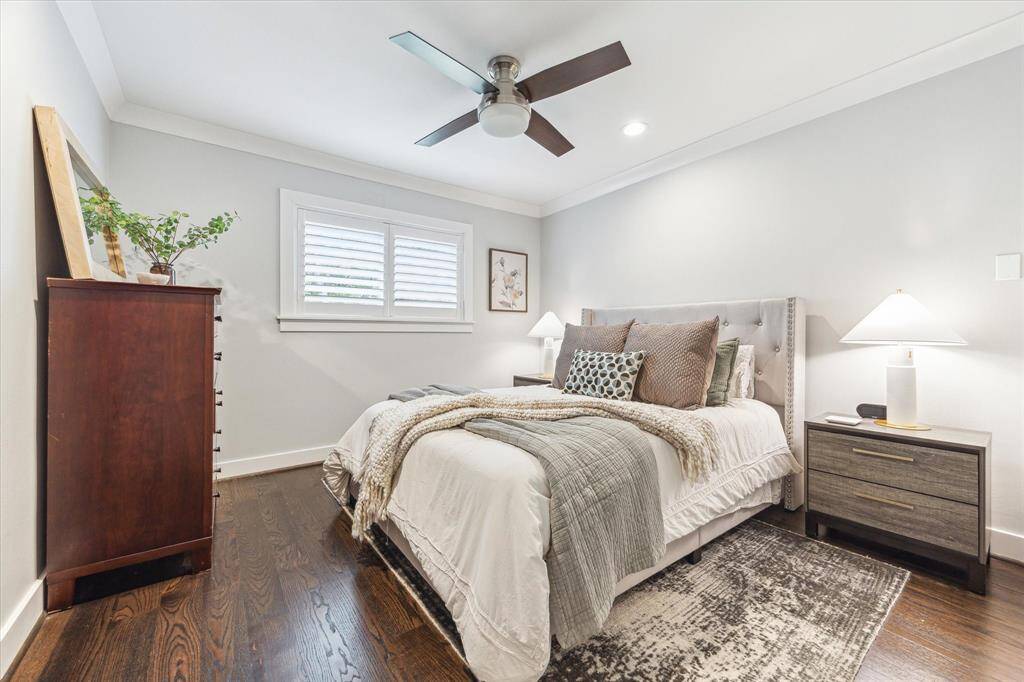 Guest bedroom on second floor with custom molding and hardwood floors.