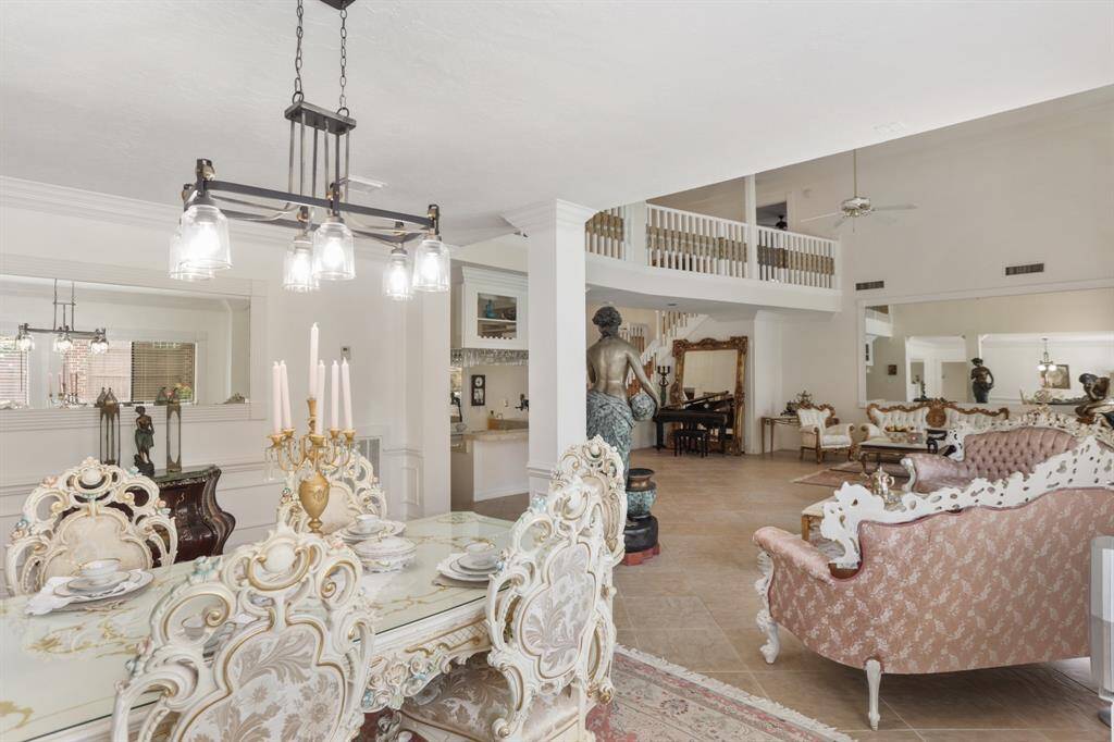 Formal Dining room with chandelier, wall of windows, crown molding and gorgeous pillars dividing the two formal areas.