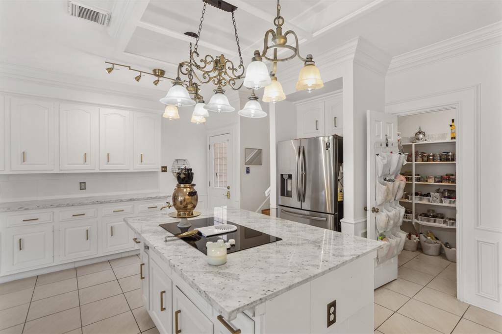 Convenient back stairs leading up to 3 additional bedrooms and game/sports area. Lots of cabinets with custom hardware, gold faucet, crown molding and a butlers area with more cabinets.