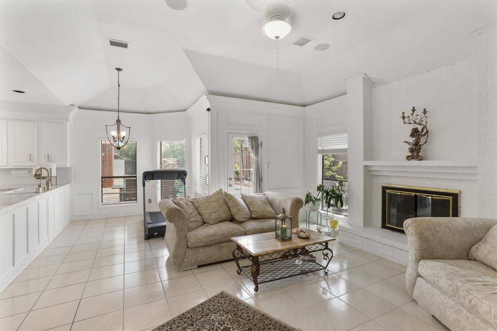 Family room open to kitchen and breakfast room with back door leading out to the amazing backyard.  Gas Log fireplace with custom screen.