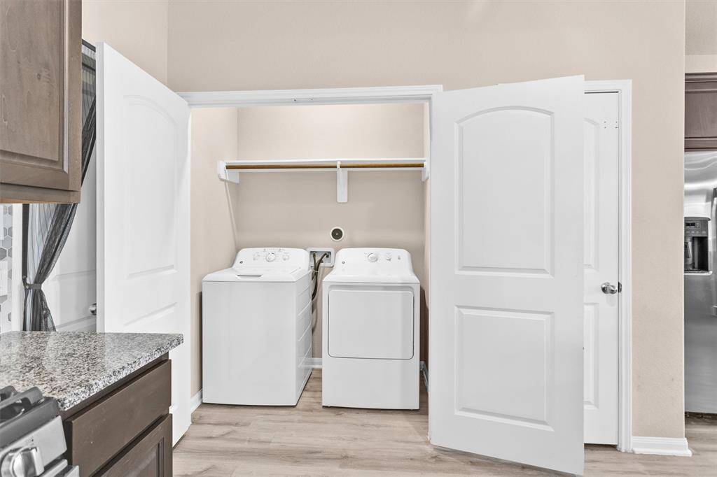 Washer & Dryer are tucked behind double doors and feature built-in shelving and a hanging rack!