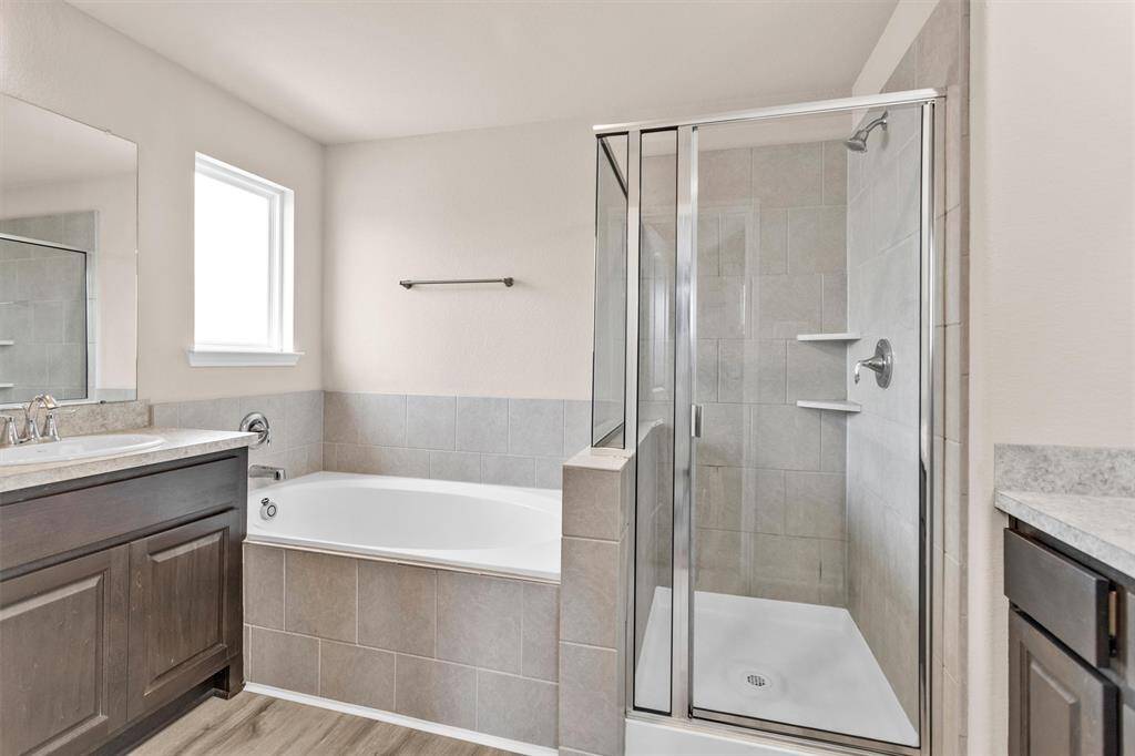 The Primary Bathroom features a soaking tub, a walk-in shower and natural light filtering through the privacy window.