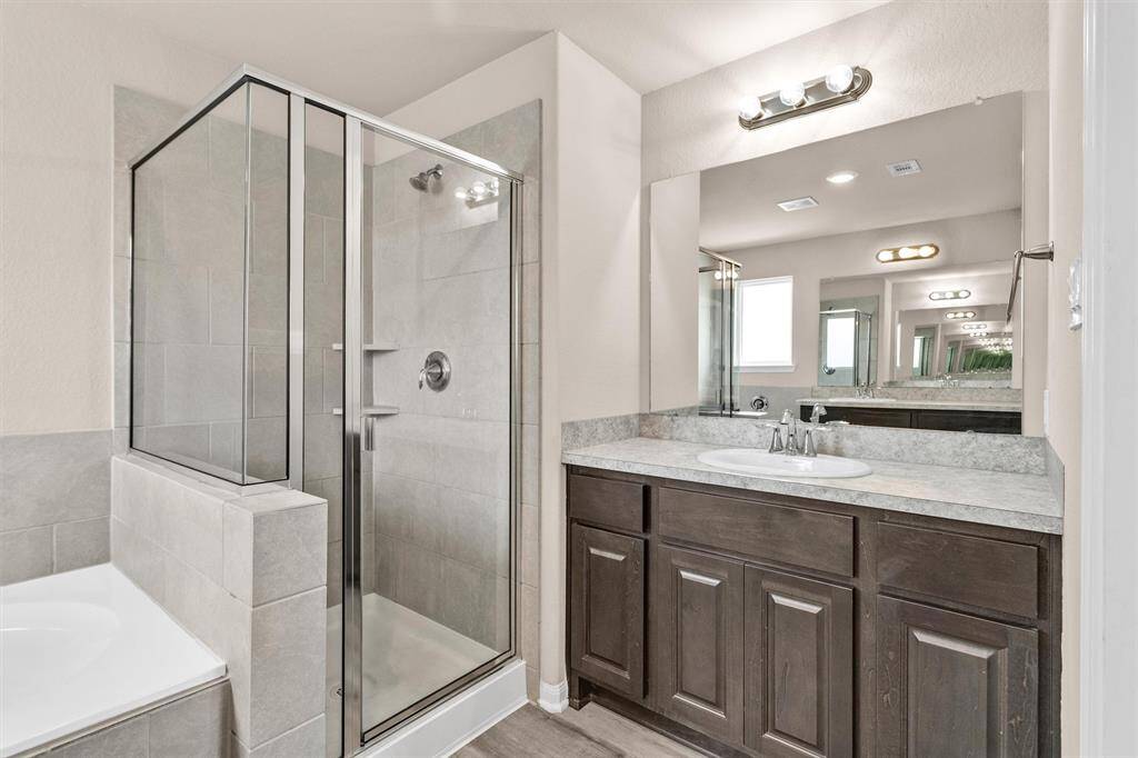 The modern, Primary Bathroom also features dual vanities!