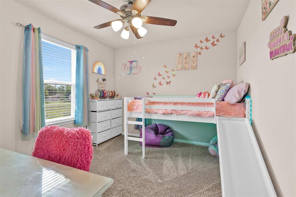 Bedroom #3 receives lovely natural light through a large window & features neutral carpet and a ceiling fan.