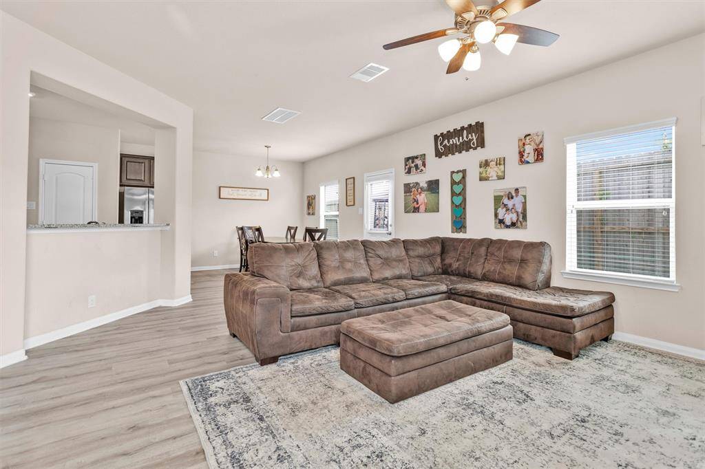 The Family Room features vinyl wood plank floors, a ceiling fan and large windows looking out to the Backyard!