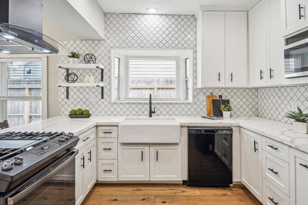 The updated kitchen features quartz countertops, a gas range, apron-front sink, stylish backsplash and cabinets to the ceiling providing ample storage. The extended window over the sink lets in an abundance of natural light.