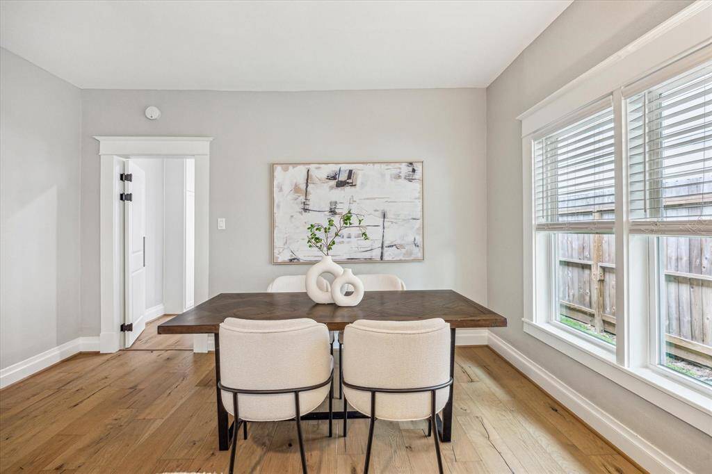 he dining area is framed by two large windows that fill the space with natural light.