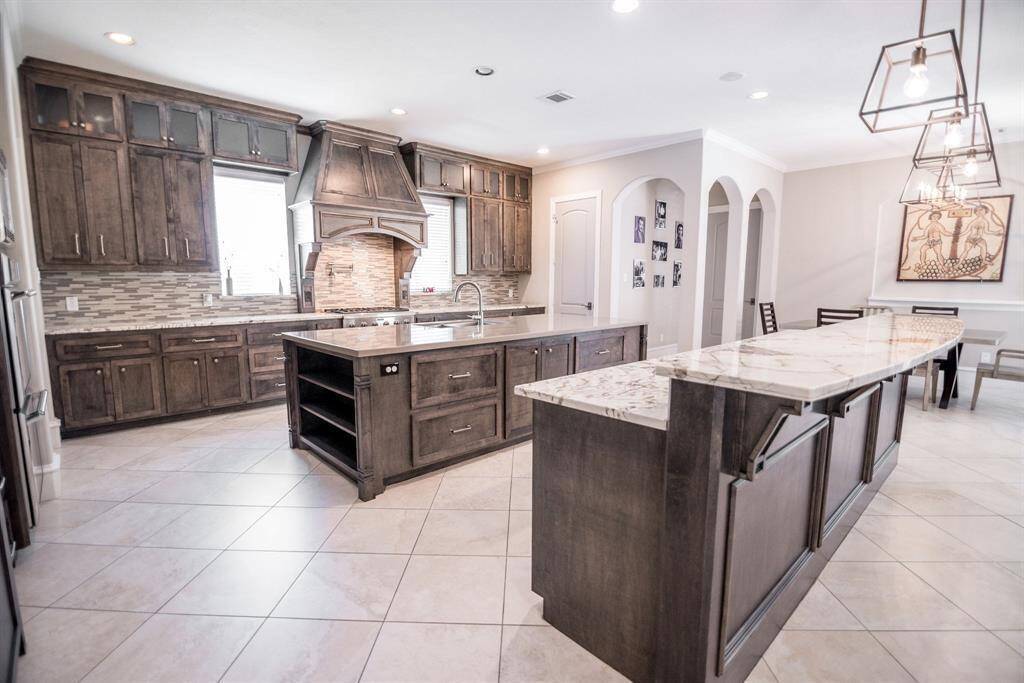 Elegant kitchen with open-concept design, featuring Blanc du Blanc granite countertops and a sleek quartz island.
