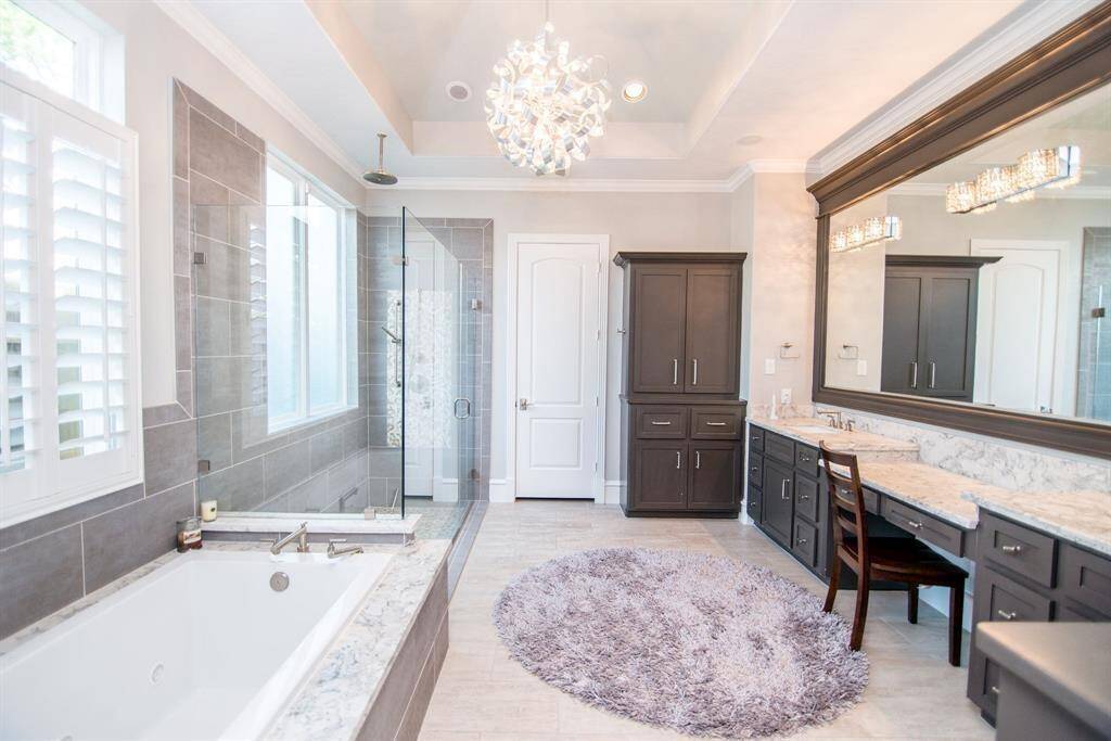 Spacious primary bathroom with double sinks and an expansive mirror.