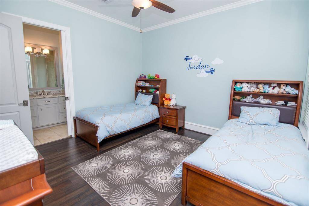 First-floor bedroom with ceiling fan and private en suite bathroom.