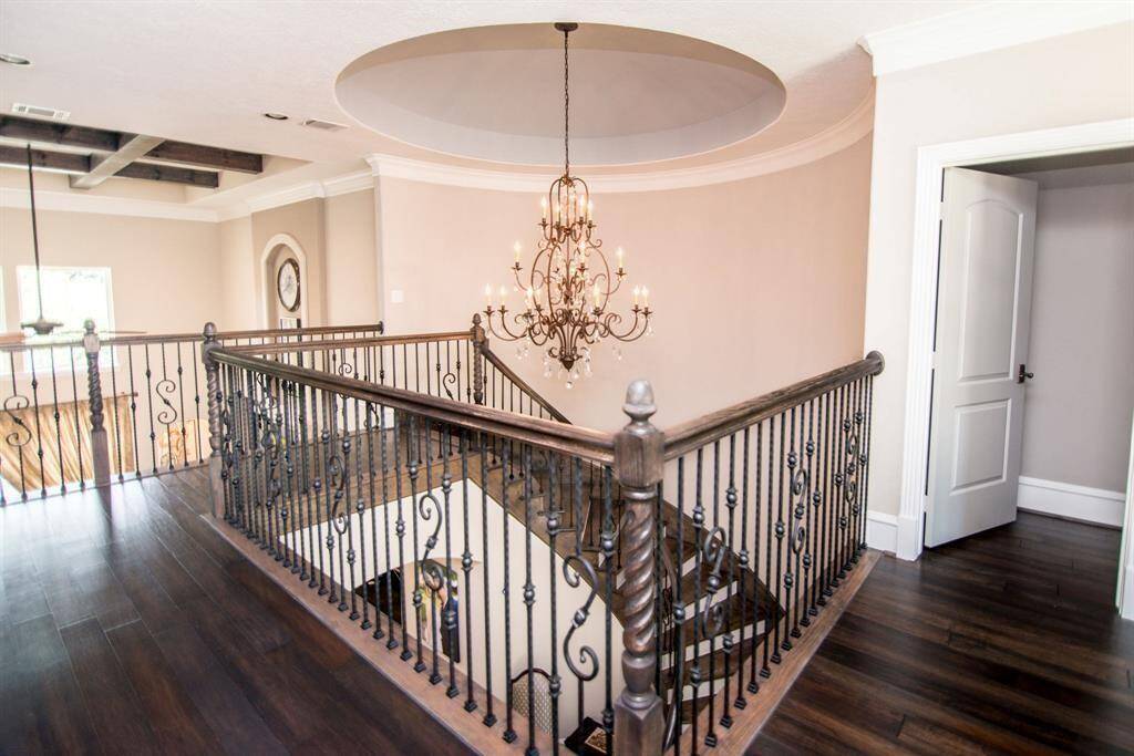 Experience timeless elegance with this stunning rotunda featuring a graceful winding staircase, exquisite wood flooring, and a beautifully detailed railing.