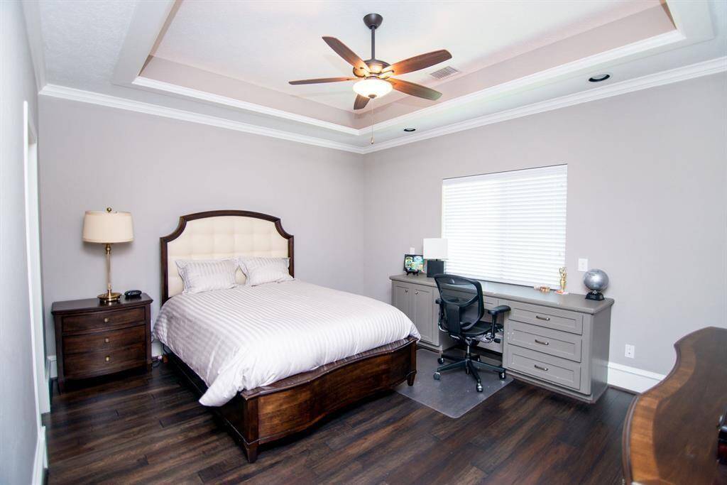 Bedroom with elegant coffered ceiling with abundant natural light from the large window.