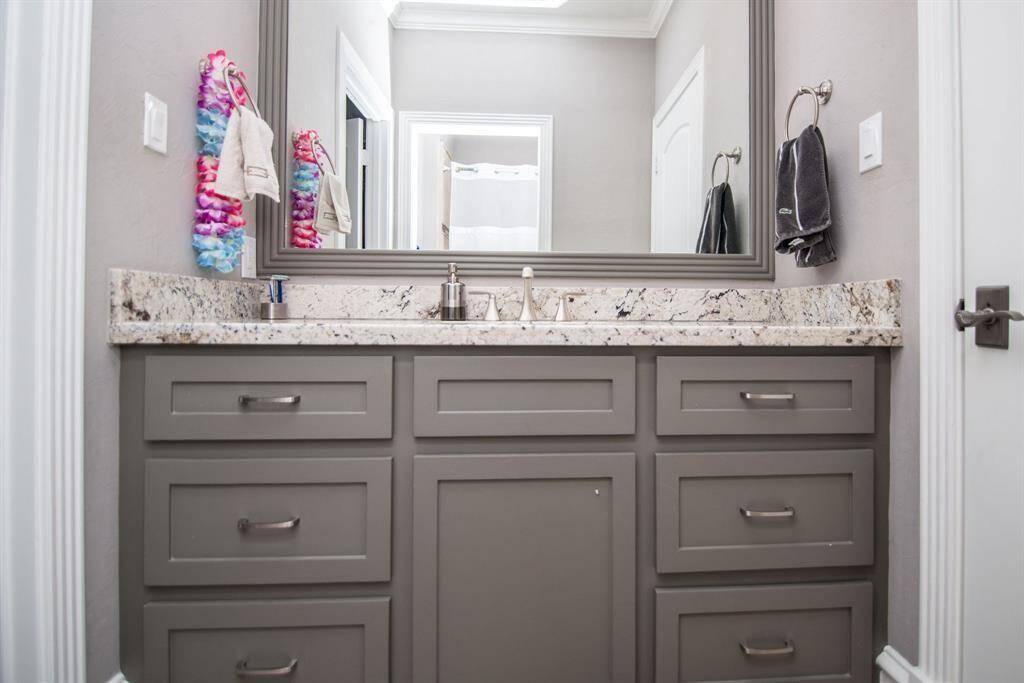 Luxurious en suite bathroom featuring abundant storage and a spacious mirror.
