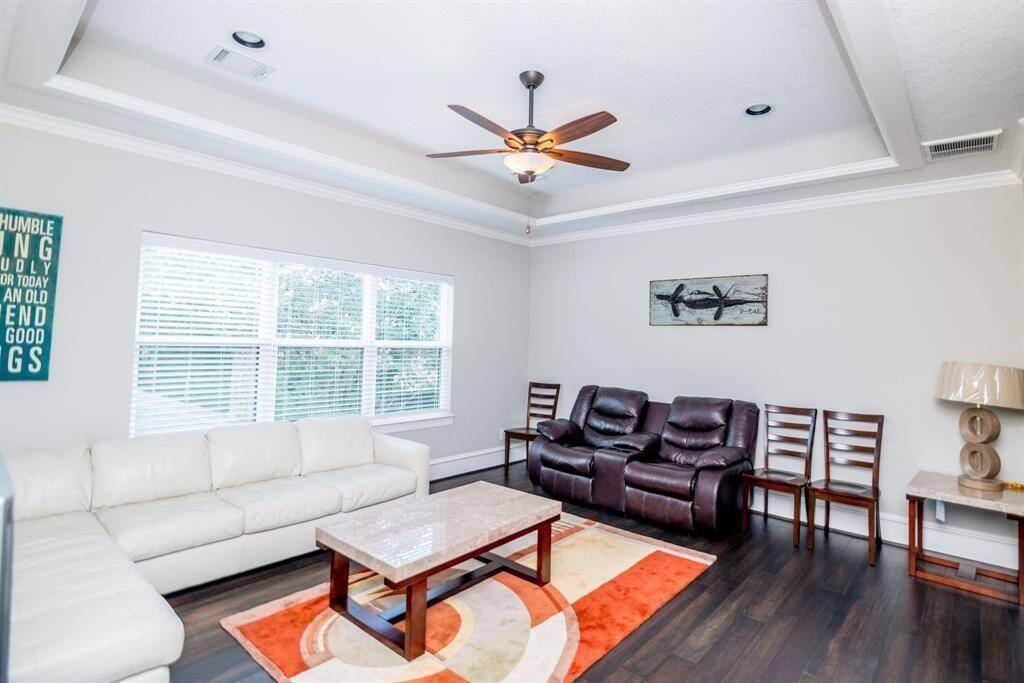 Bright and inviting game room featuring large windows and a ceiling fan for comfort.