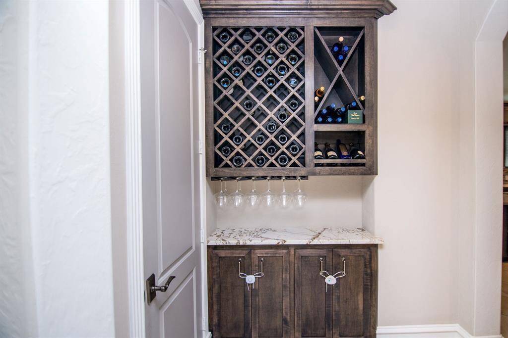 Elegant wine nook featuring a custom wine rack, marble countertop, and glass holders—perfect for wine enthusiasts.